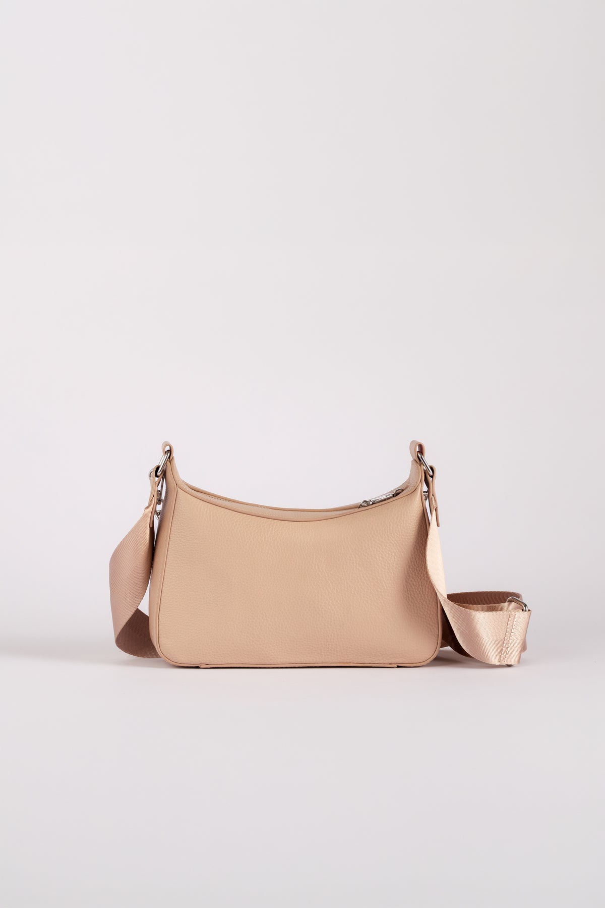 A small shoulder travel bag branded Jupiter in a beige color, featuring a matching detachable strap and a zippered pouch attachment, set against a plain light gray studio background. The handbag comes with safety features such as anti theft zipper, slash proof material and RFID protection.